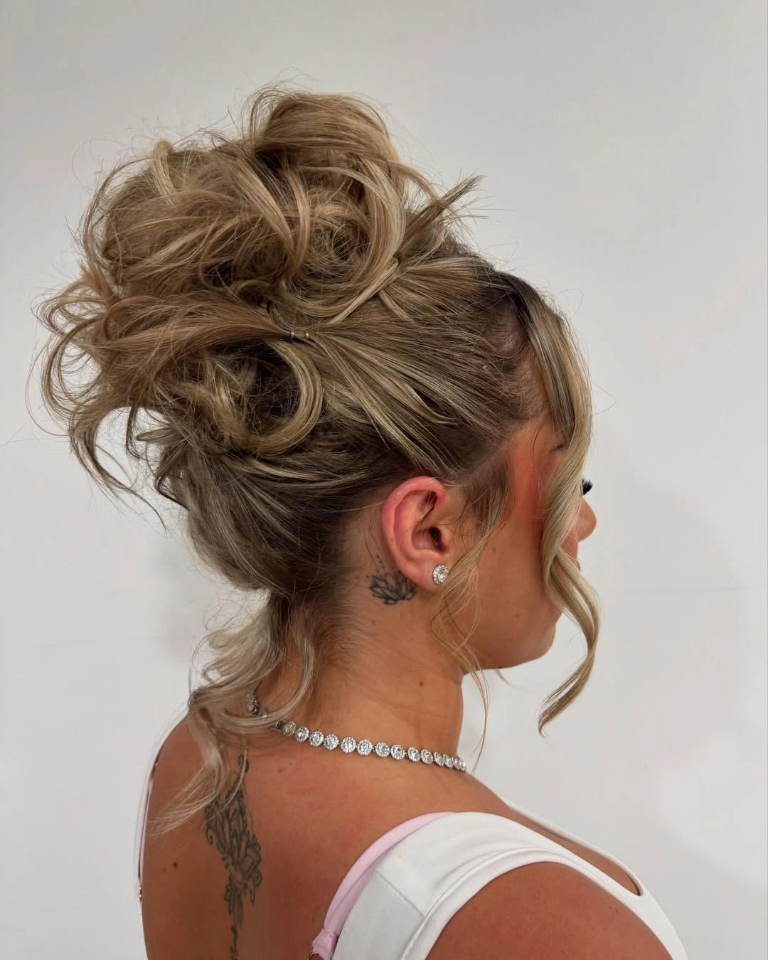 High updo with overlapping loops and loose curved pieces