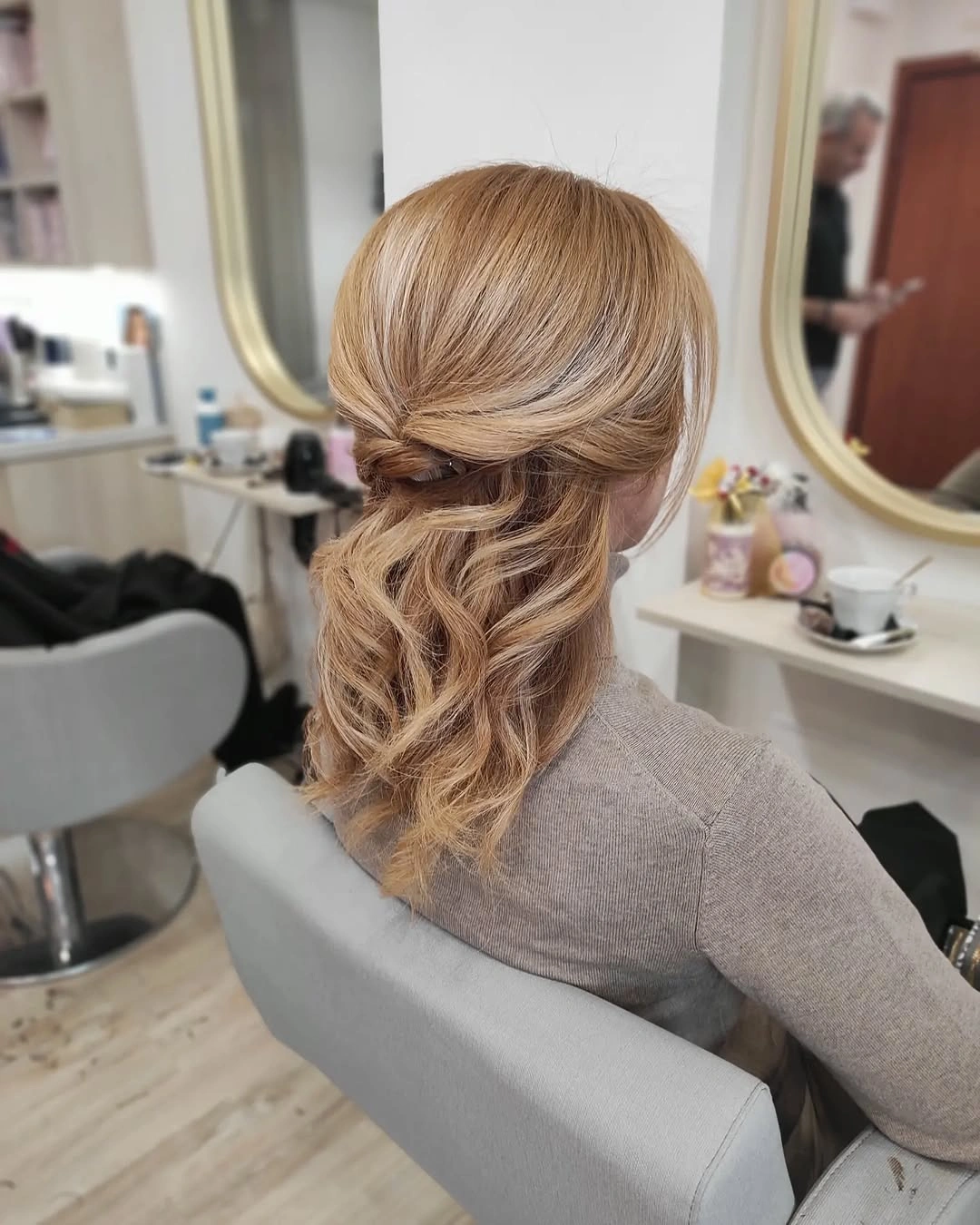 Blonde low gathered hairstyle with wrapped section and wavy ends