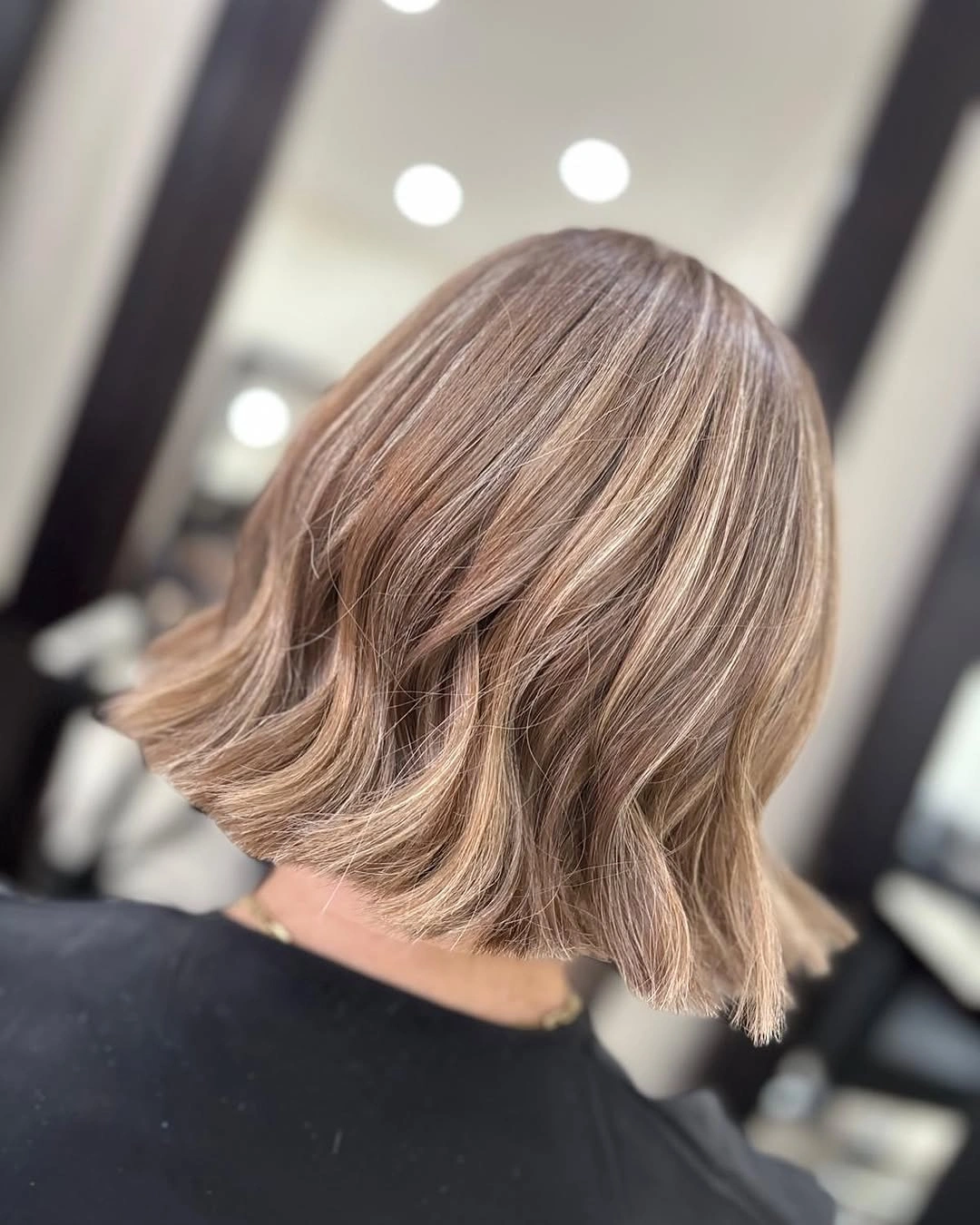 Short light brown bob with lighter sections and flipped ends