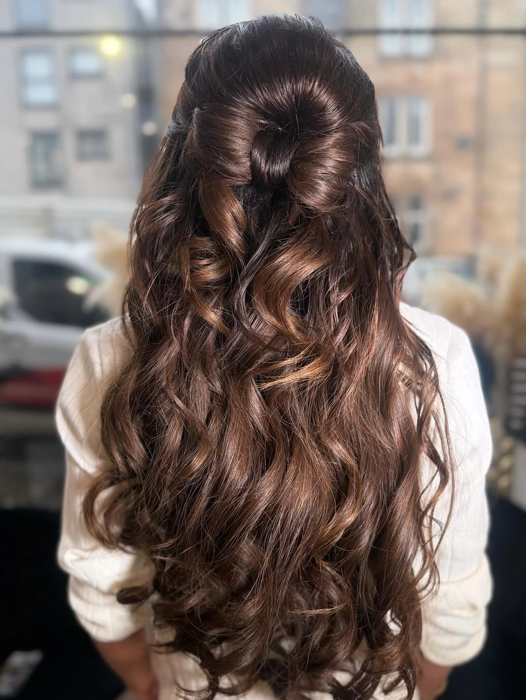 Long dark curls with bow-shaped loops at the back