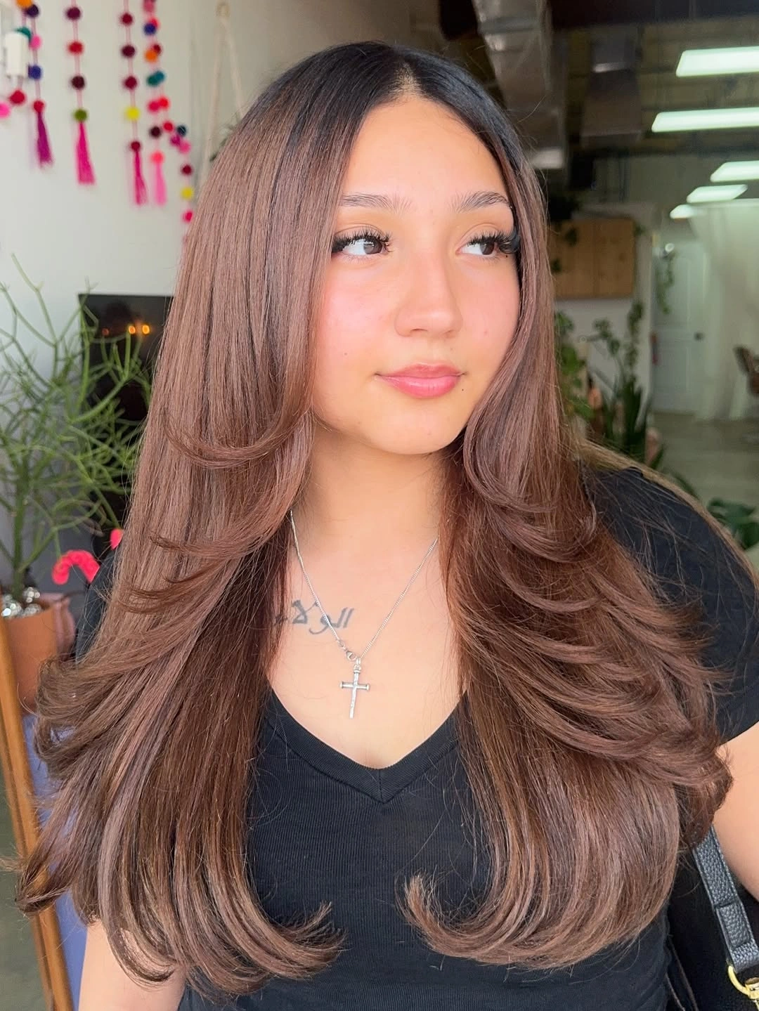 Long warm brown hair with face-framing layers and curved ends