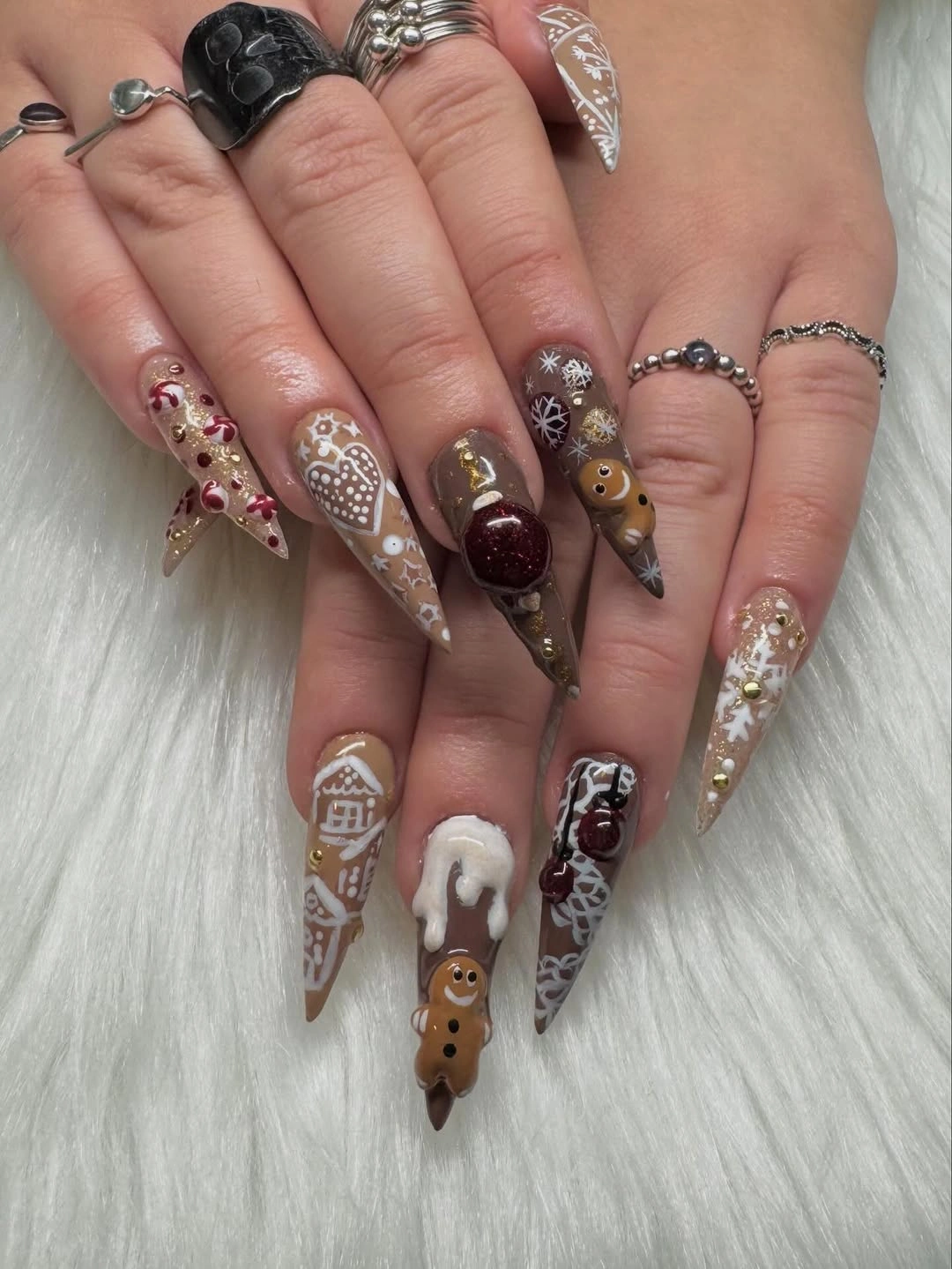 Long pointed brown nails with gingerbread, houses, snowflakes, and candy details