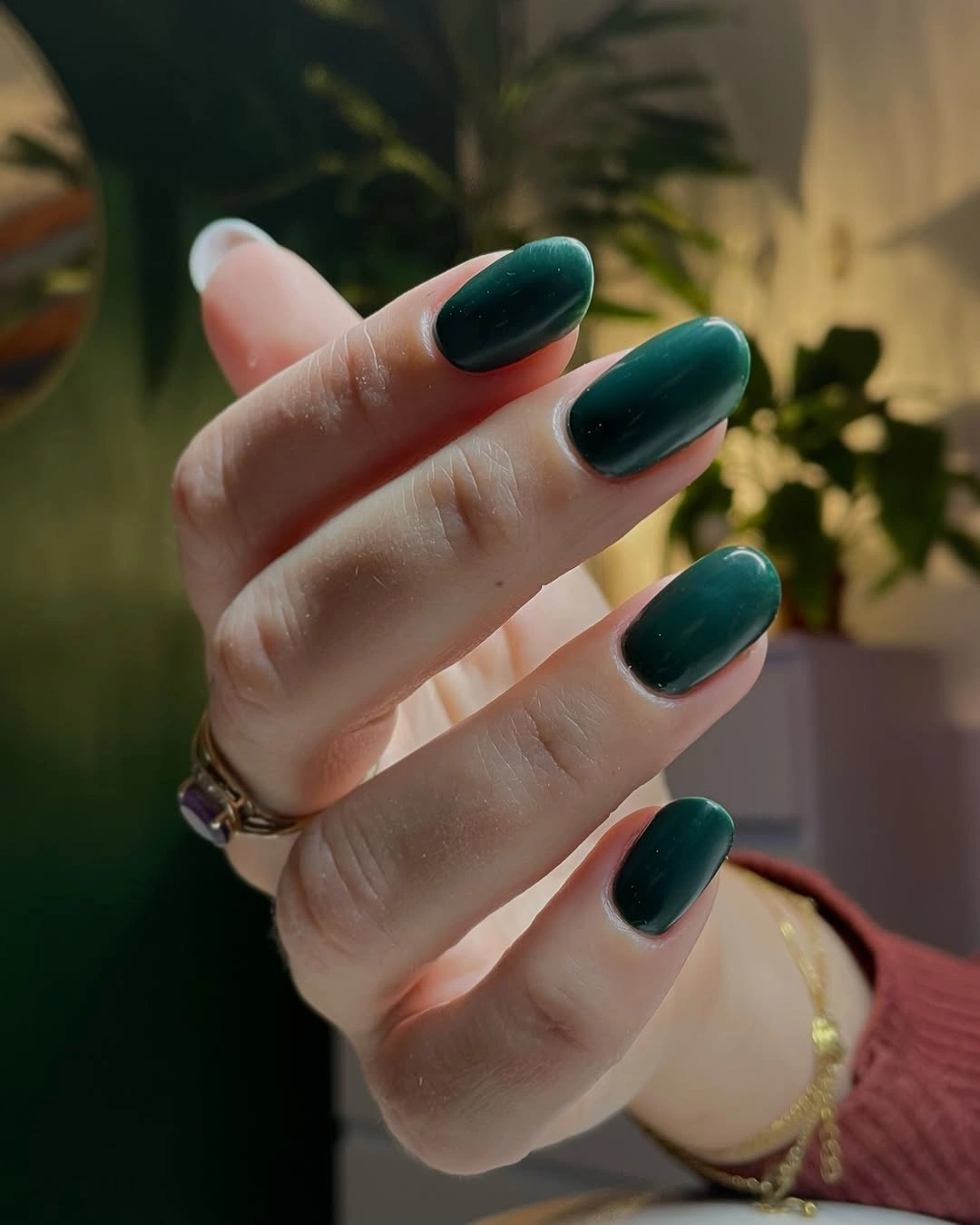 Medium oval nails covered in deep luminous forest green
