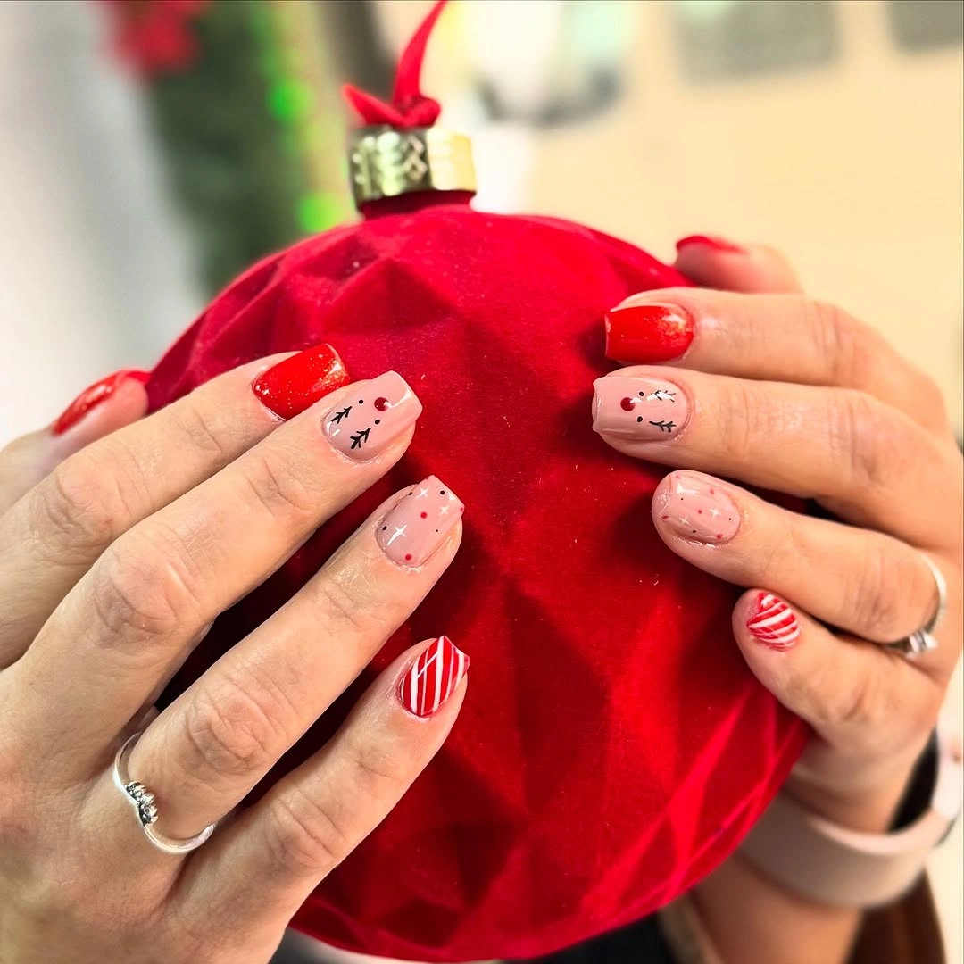 Short red and blush nails with stripes, dots, and face details