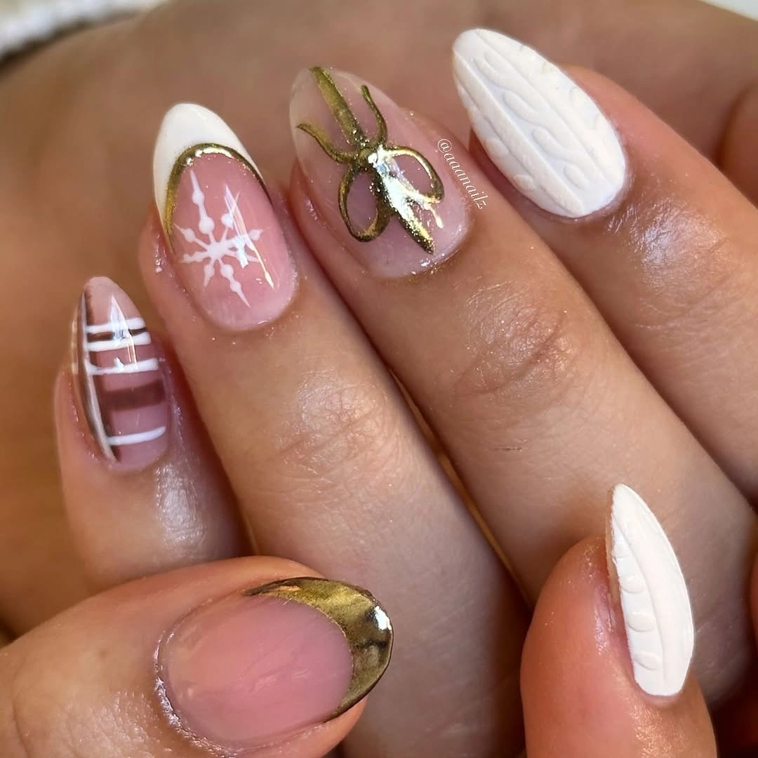 Almond pink and white nails with gold details and snowflake accents