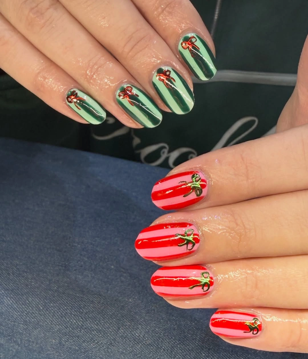 Short green and pink striped nails with red and green bows