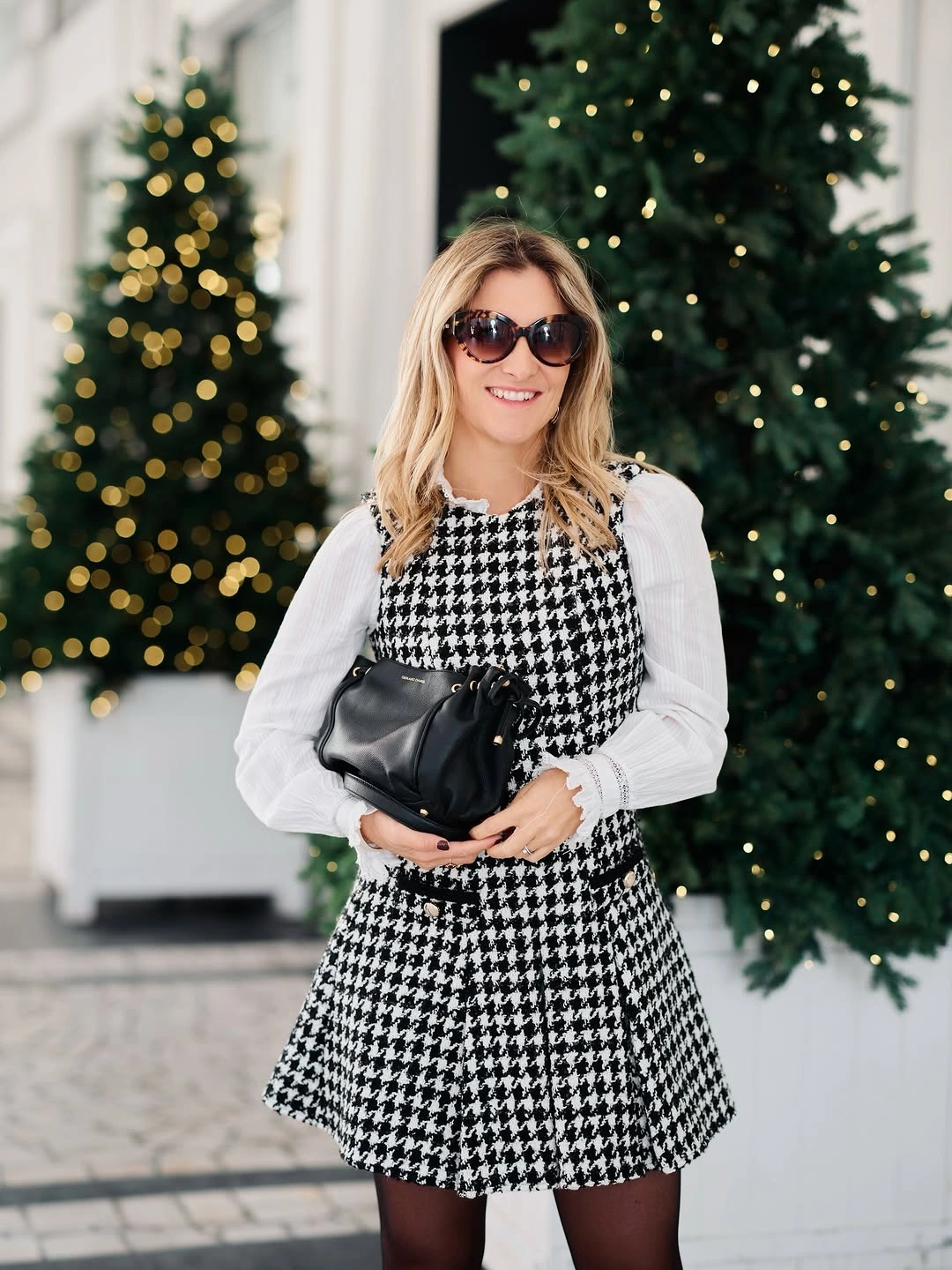 Houndstooth mini dress layered over white blouse with black tights