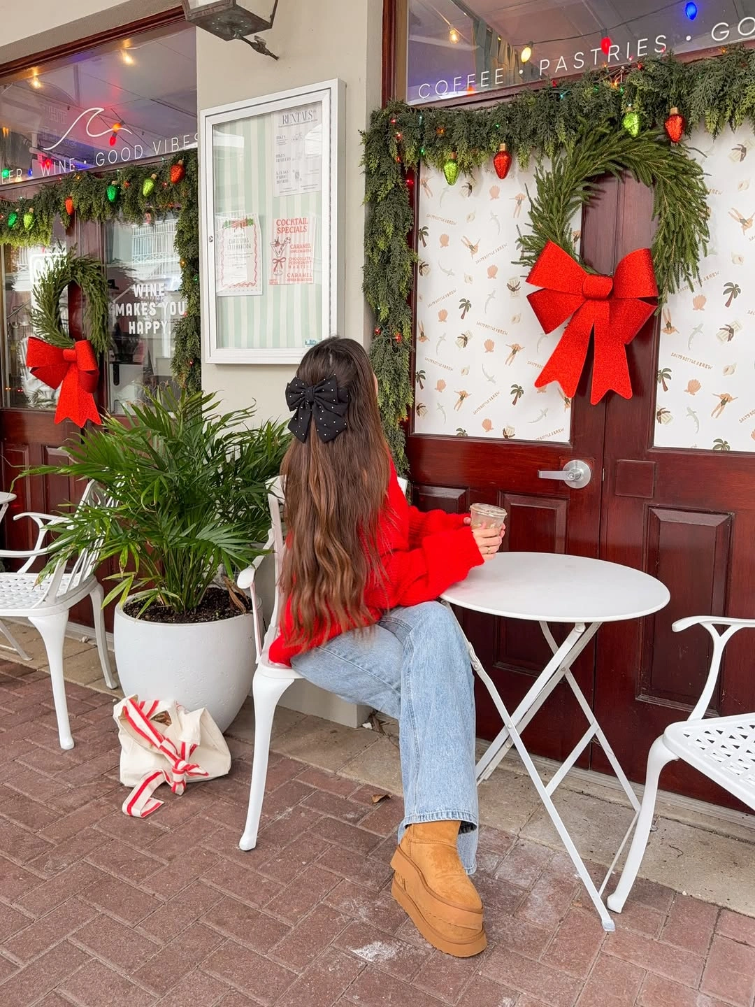 Red sweater with loose jeans tan boots and black bow
