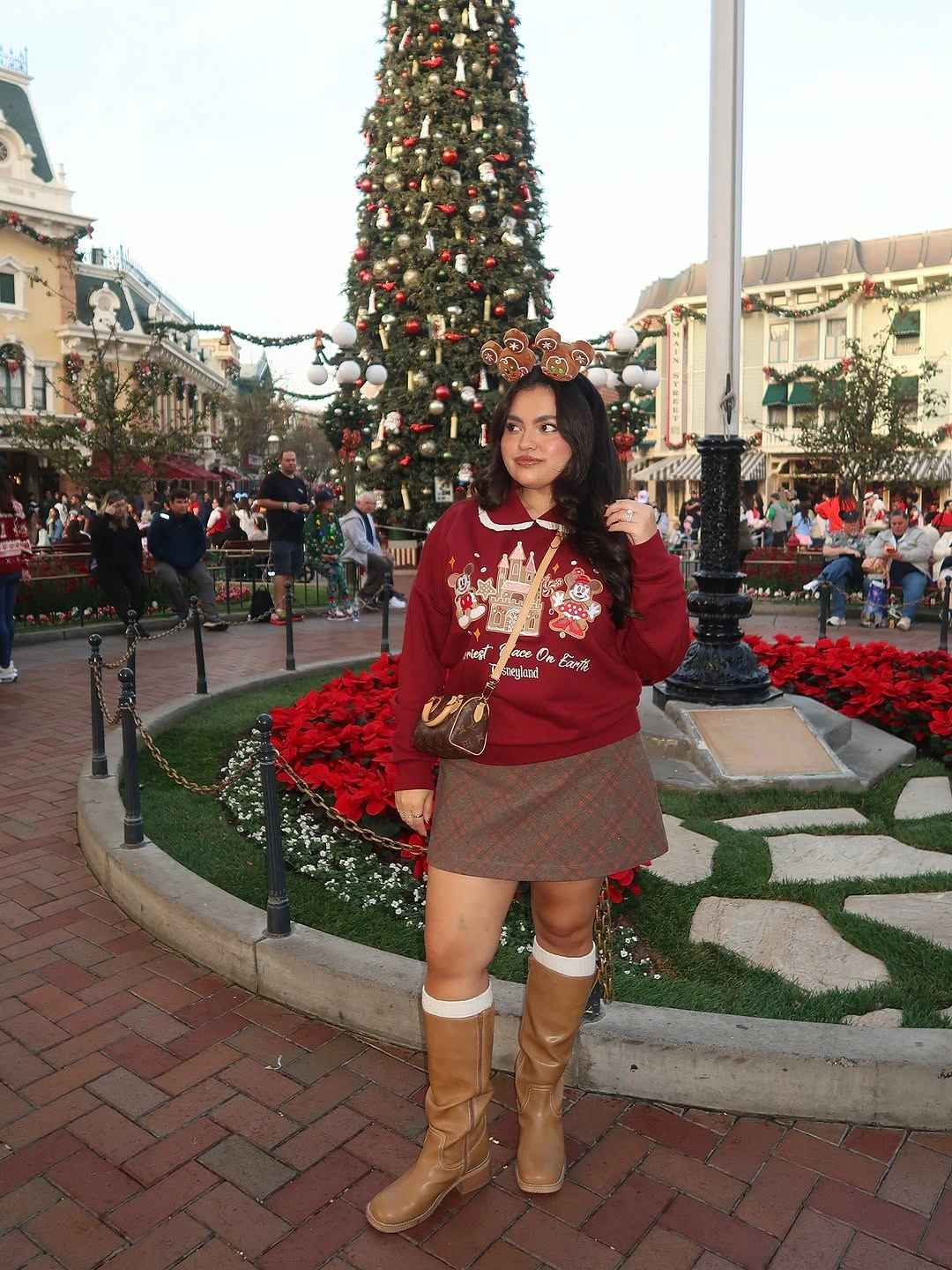 Red graphic sweatshirt with plaid skirt and tan boots