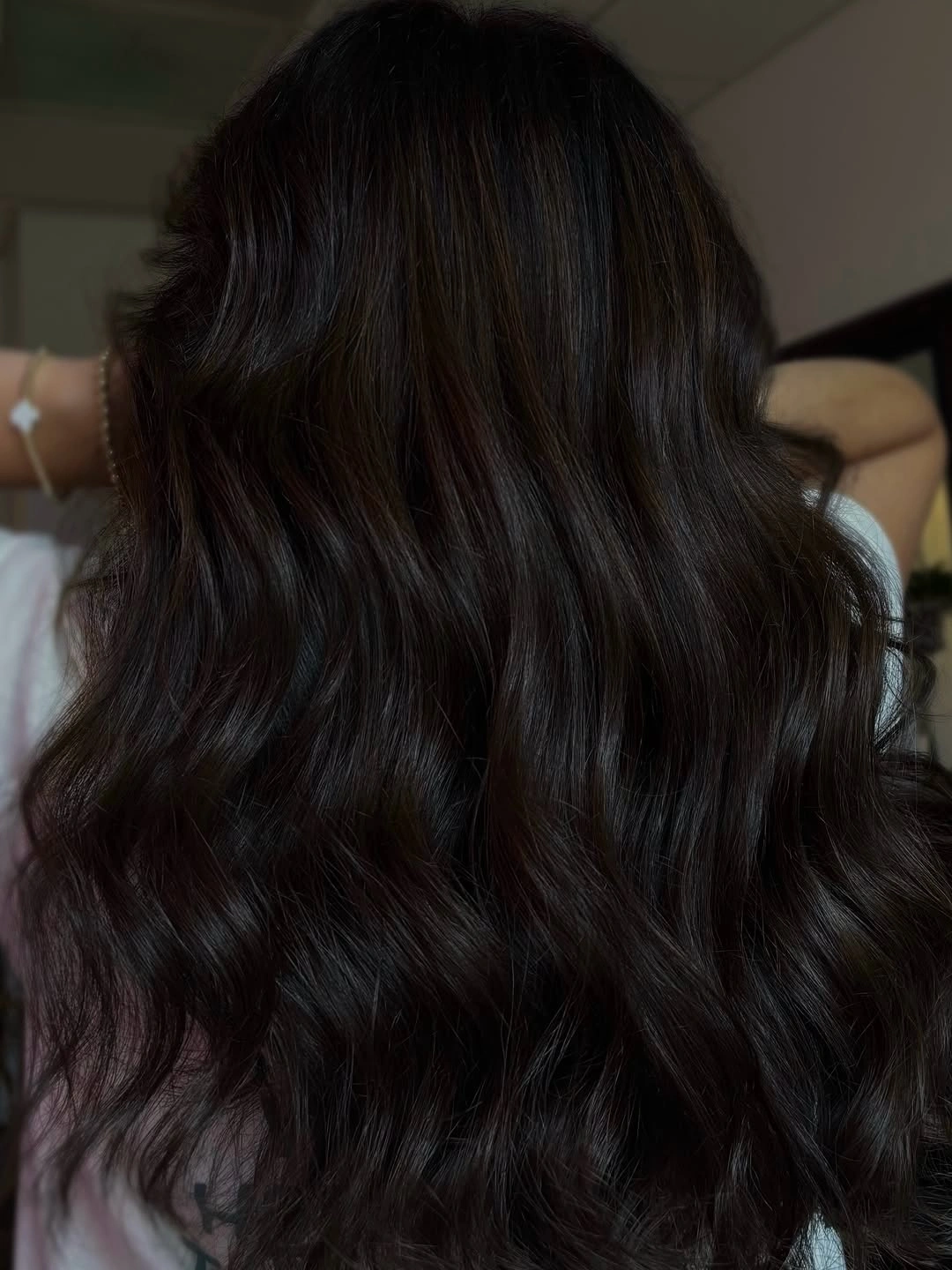 Long near-black brunette waves in a low-light view