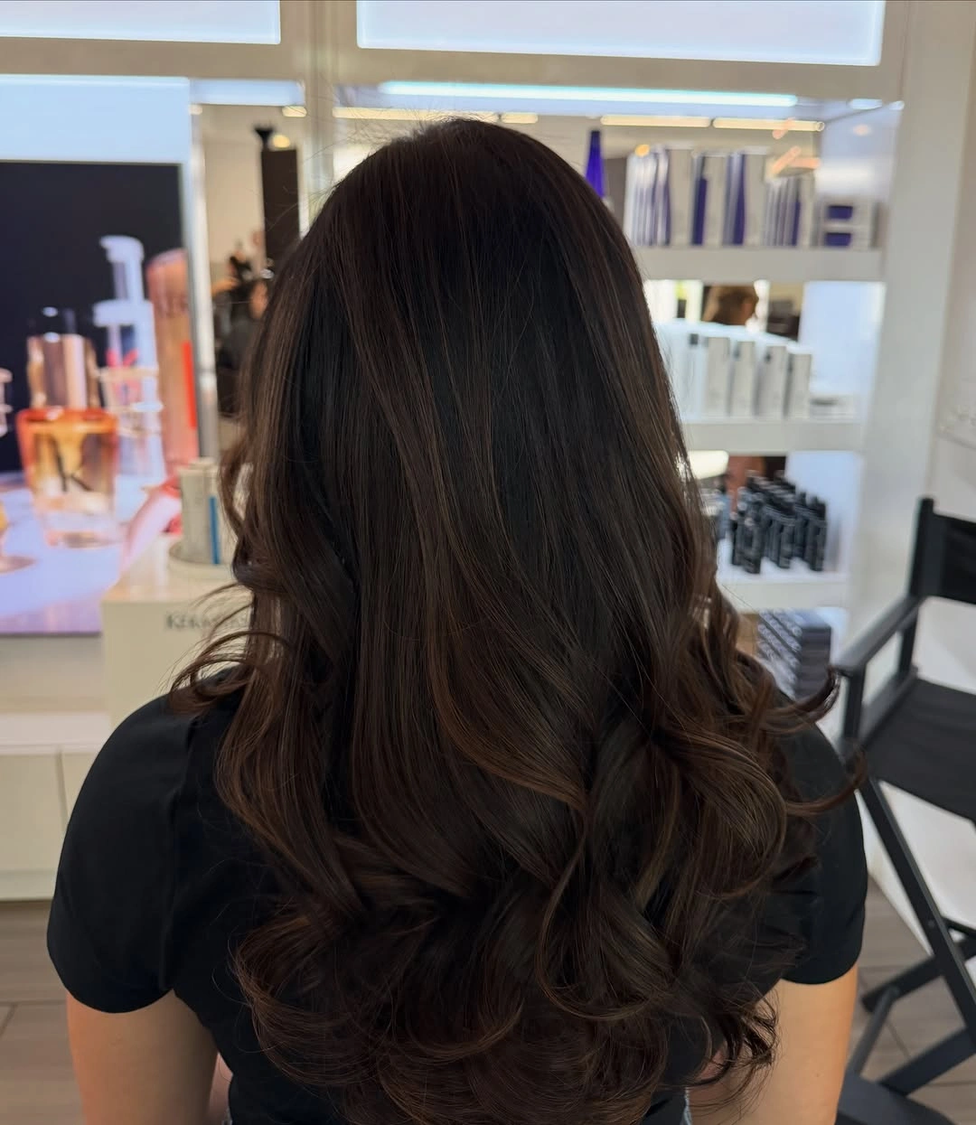 Back view of long layered brunette hair with curled ends