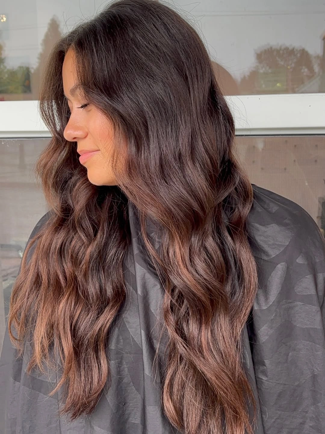 Long brunette waves with rose-copper ribbons through the ends
