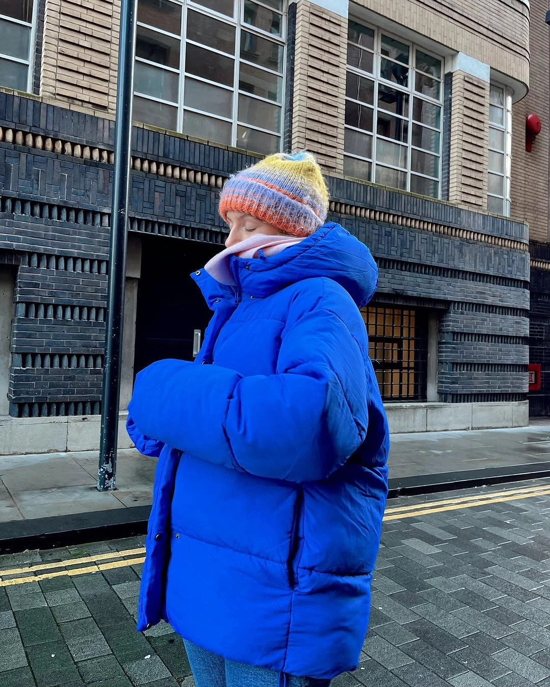 bright cobalt puffer, lilac scarf and pale striped beanie