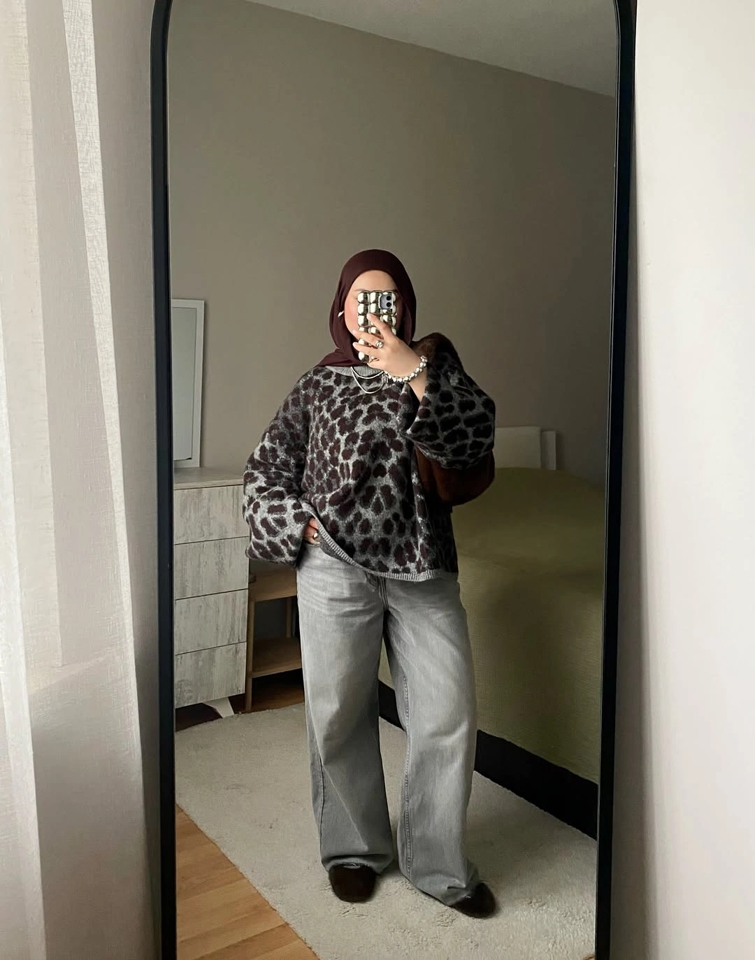 leopard-print sweater, loose gray trousers and dark shoes