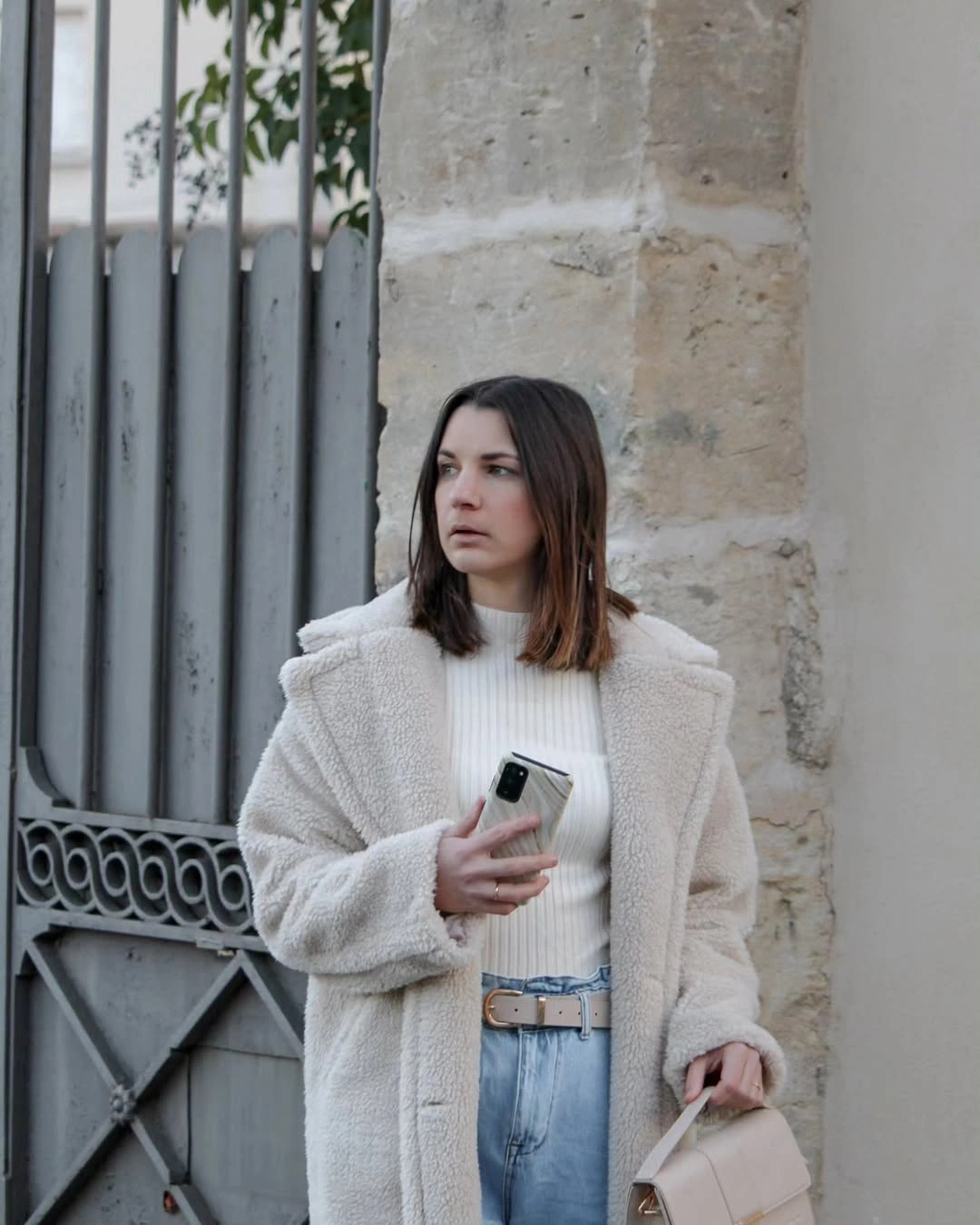 long white teddy coat, cropped light knit and straight blue jeans