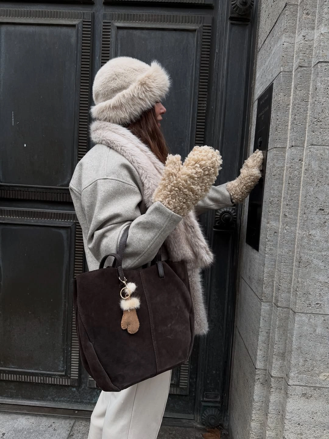 light gray coat, scarf, knit hat, white trousers, mittens and large brown bag