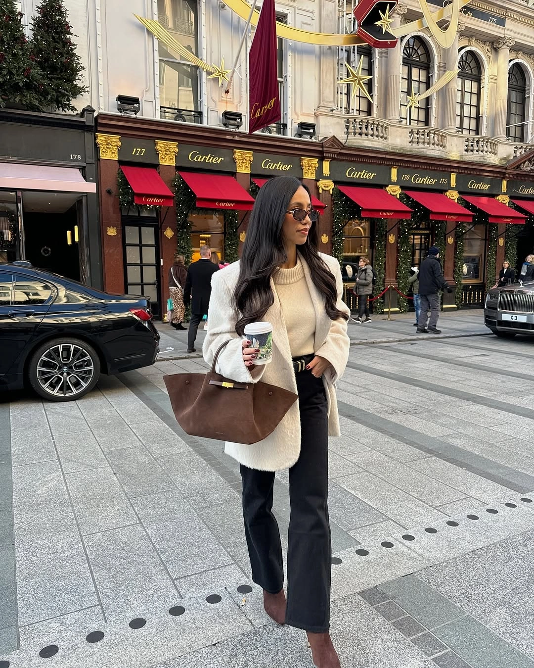 Light sweater with black trousers and a large brown bag in the city