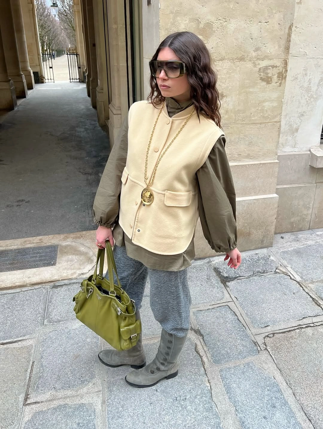 Olive jacket with cream and olive vest, gray trousers, and boots