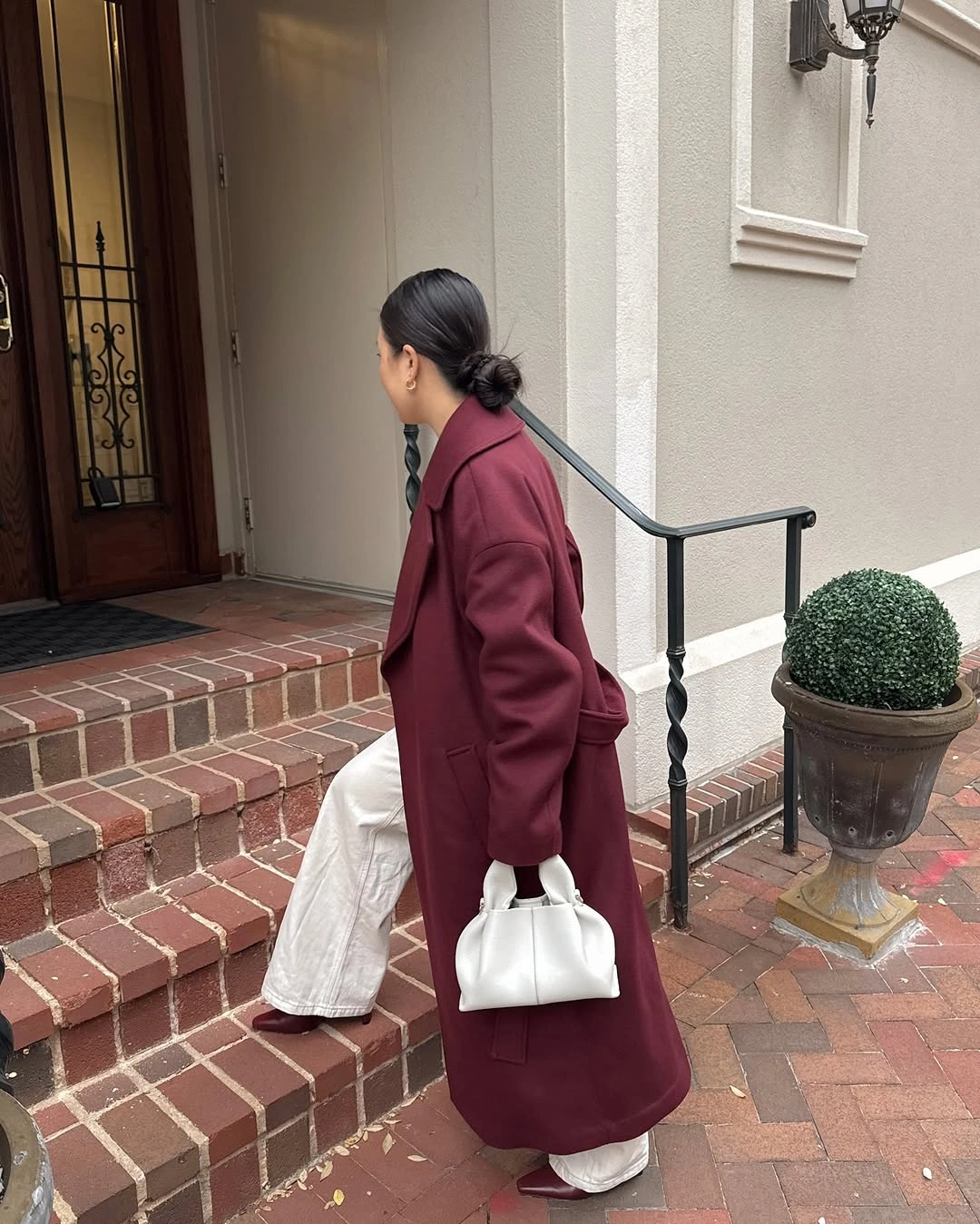 Long burgundy coat with dark top and wide white trousers