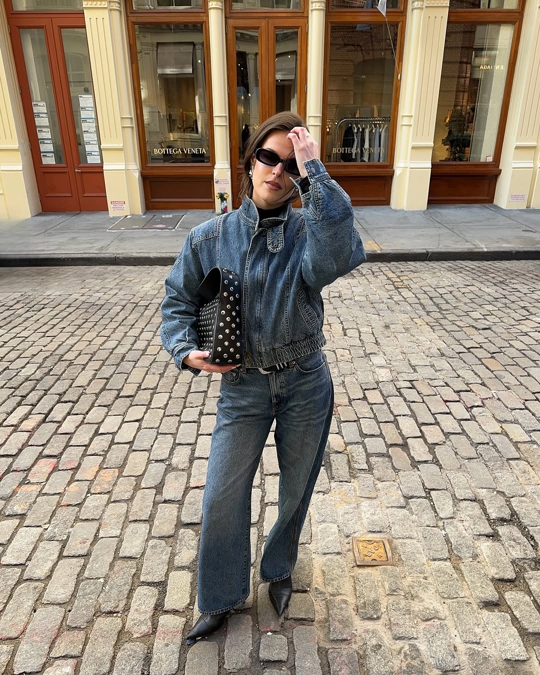 Denim jacket and jeans with black belt and studded bag