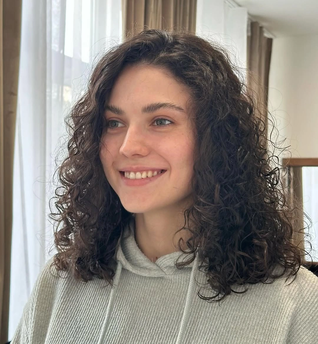 Shoulder-length dark curls with rounded volume and side pieces