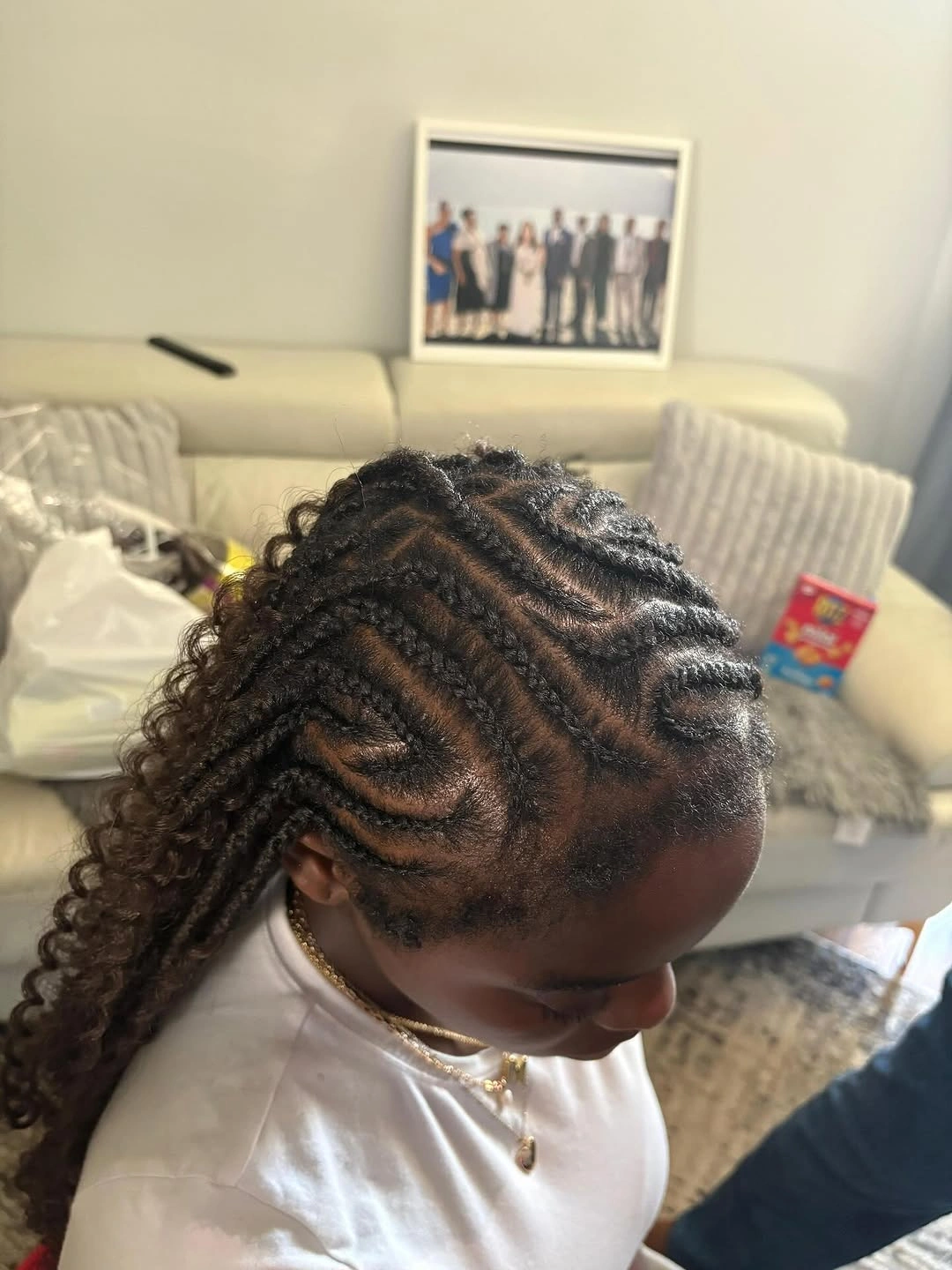 Curved cornrow-like rows leading into loose curly ends