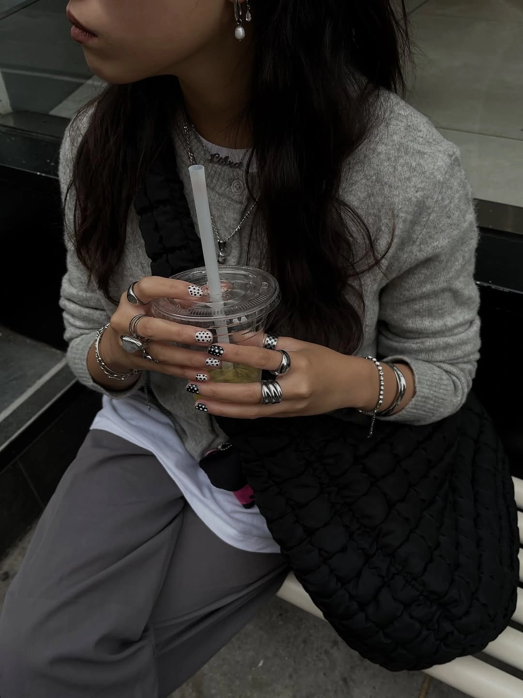 Gray sweater, white underlayer, pale trousers, and black textured-looking bag