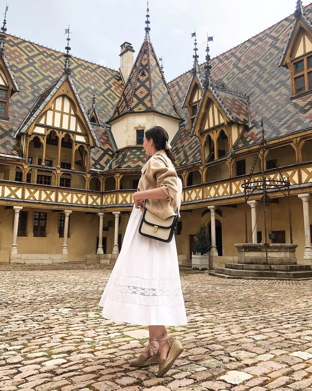 Beige sweater, long white skirt, structured bag, and pale shoes
