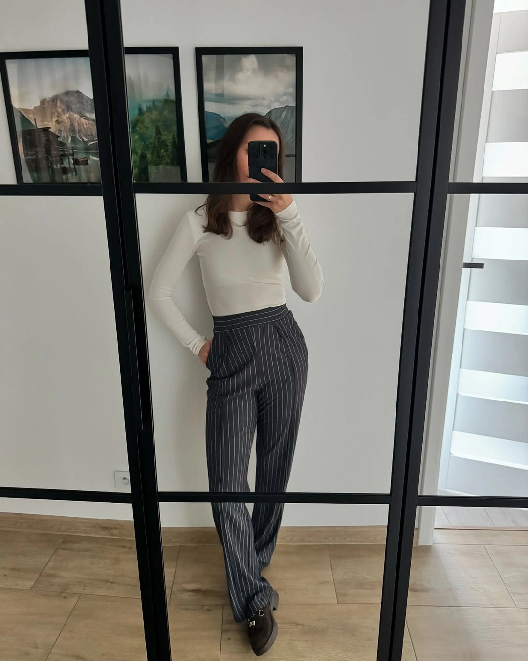 White fitted long-sleeve top with gray pinstriped trousers
