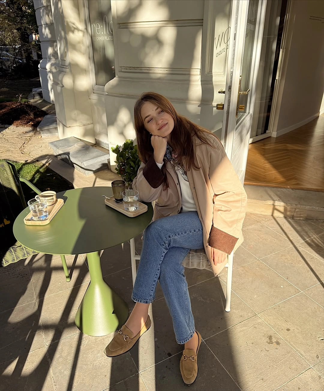 Light long coat with blue jeans and tan boots