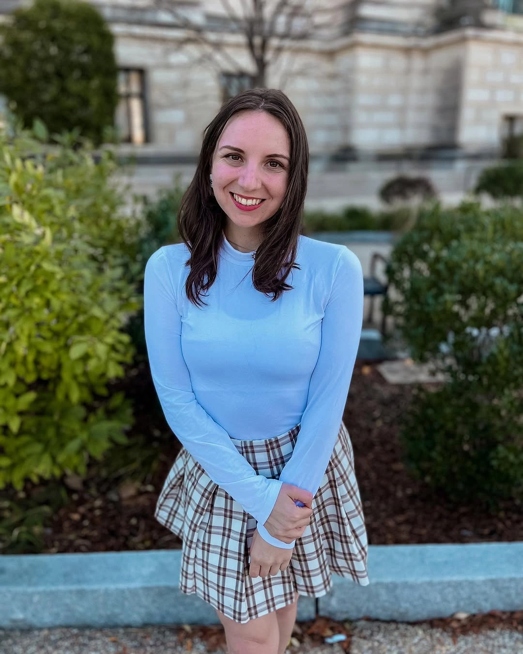 Light blue fitted top with plaid mini skirt outdoors