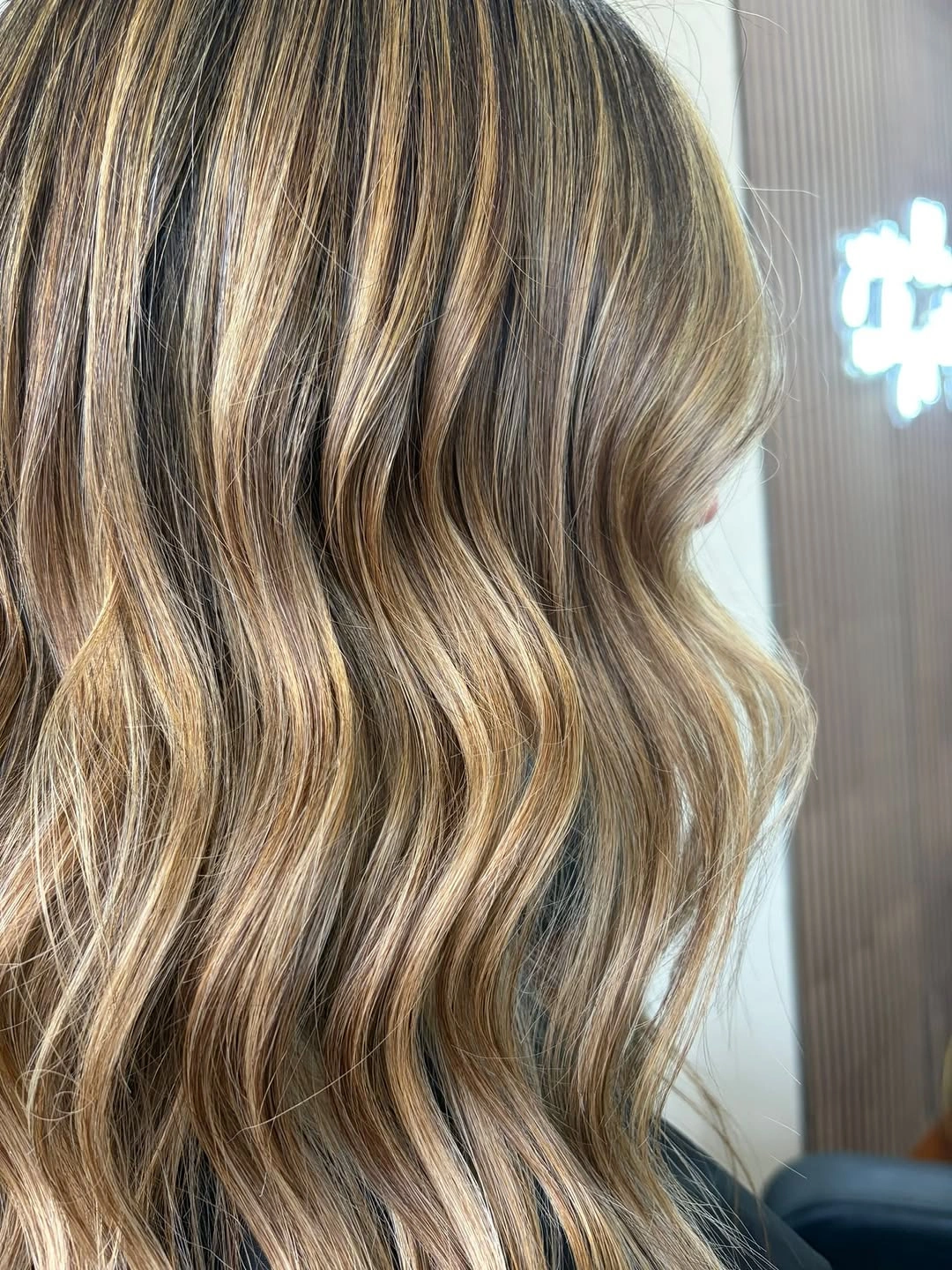Close-up brunette waves with bright beige highlighted-looking ribbons