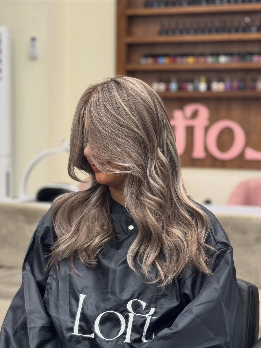 Ash-beige blonde waves with darker roots and front layers