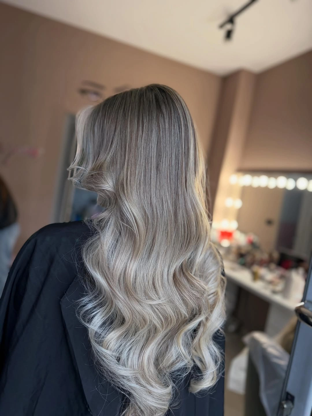 Long icy silver-blonde waves with darker root area