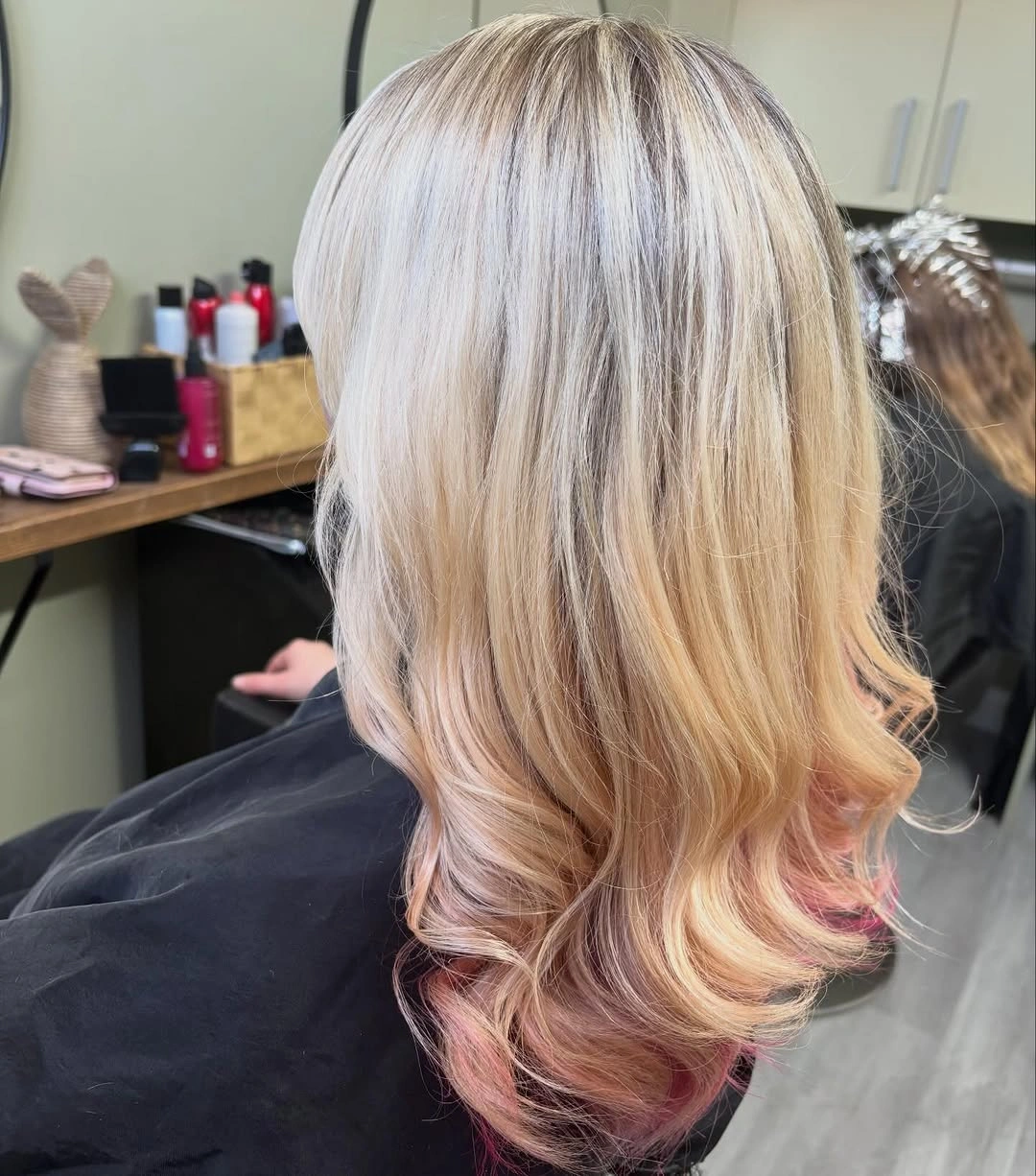 Light blonde hair with peach-pink lower ends and curled tips