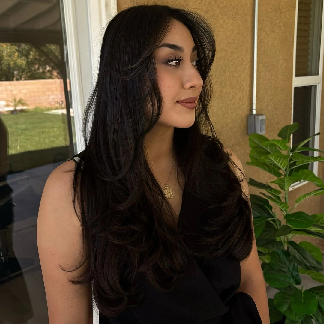 Long dark layered cut with curtain bangs and curved side pieces
