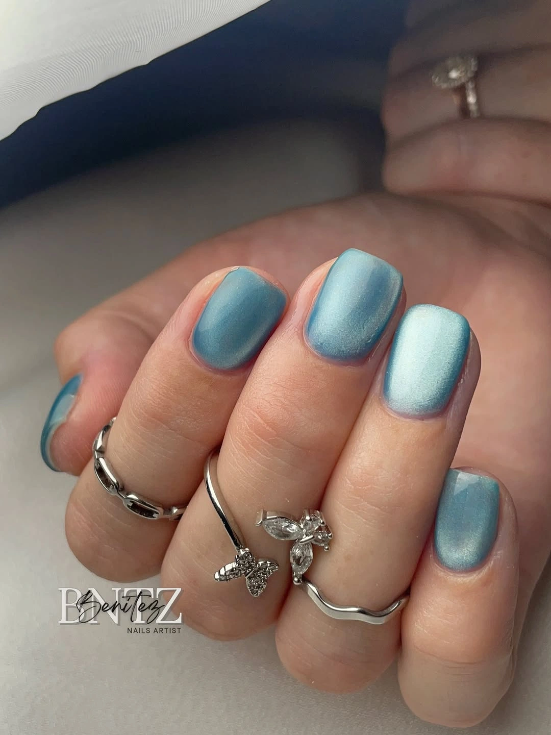 Short rounded blue nails with soft shimmery finish