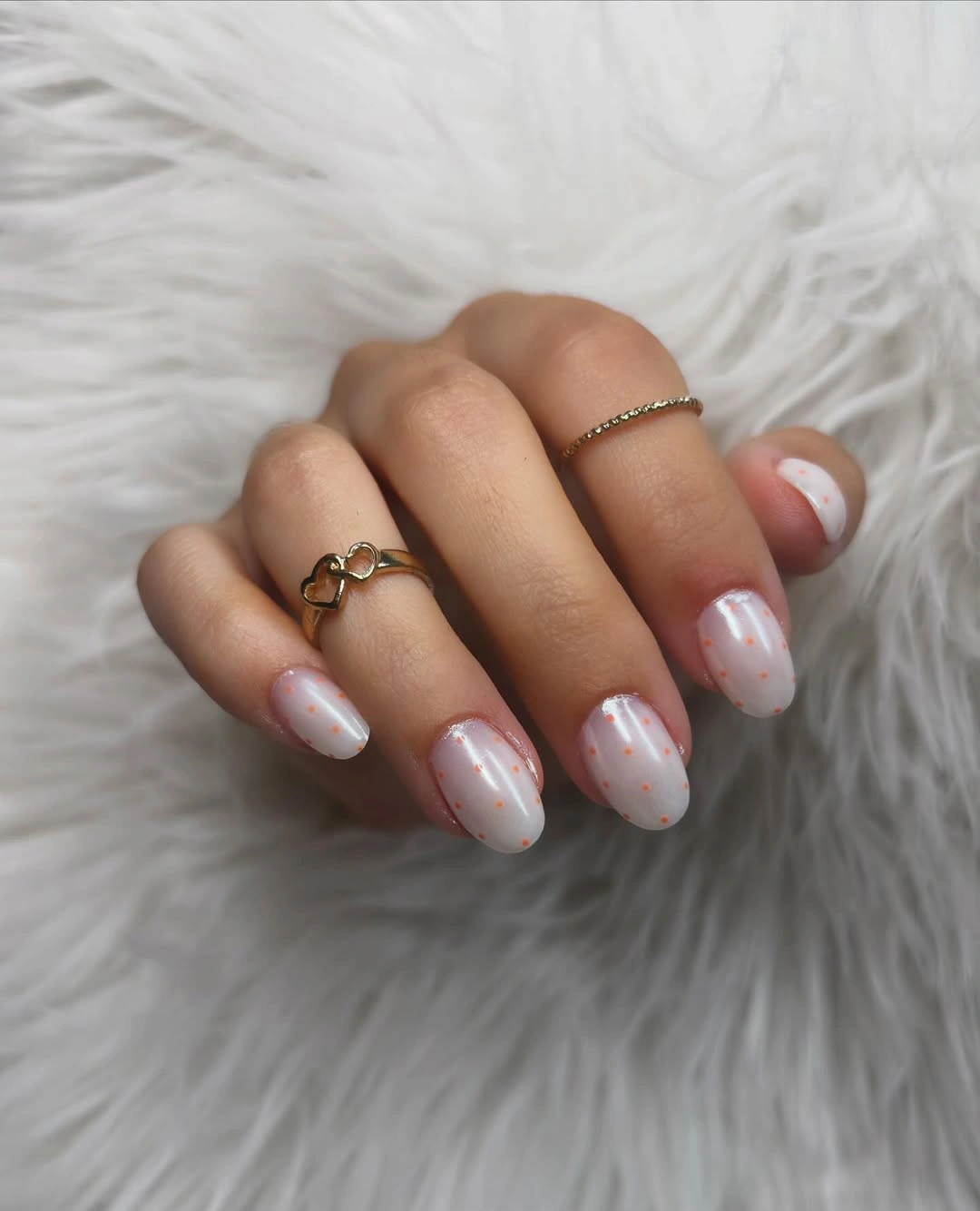 Short pale nails with tiny orange dots