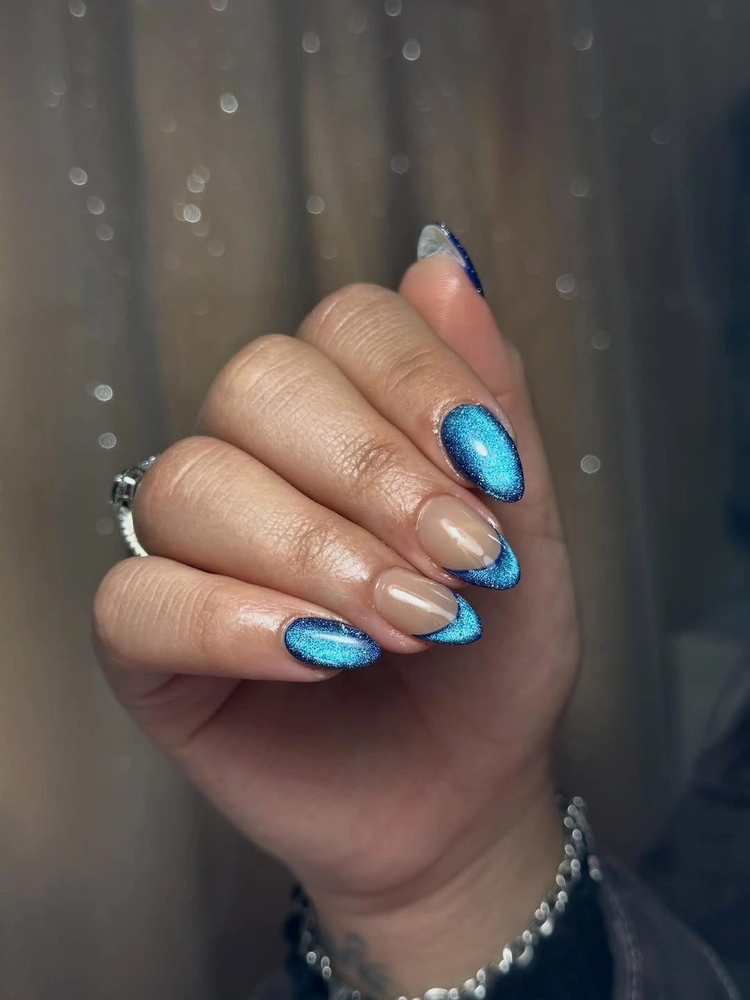 Beige nails with metallic-looking blue edges and full blue accents