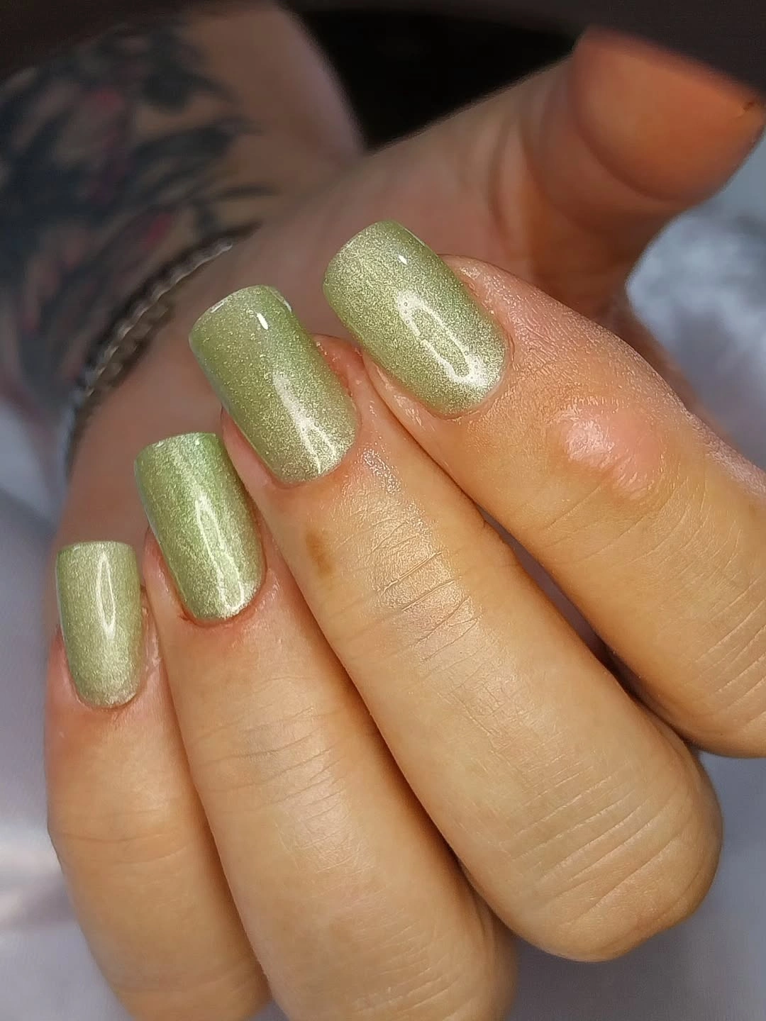 Short square green nails with fine shimmery finish