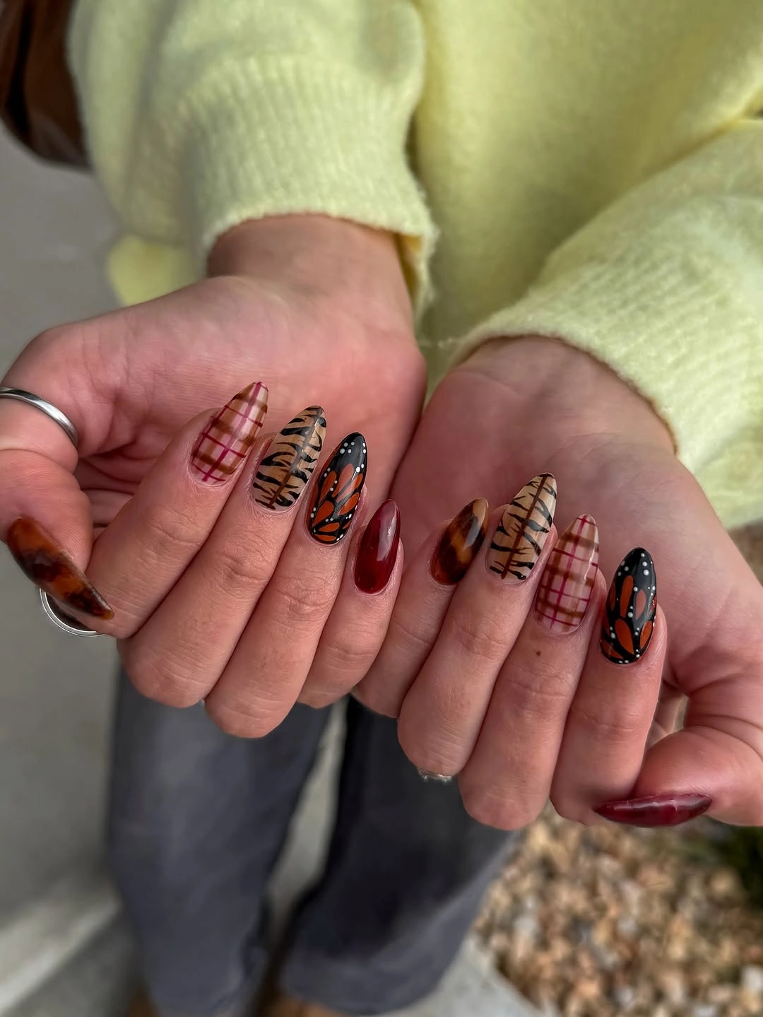 Red almond nails with plaid grids and animal-print-like stripe accents