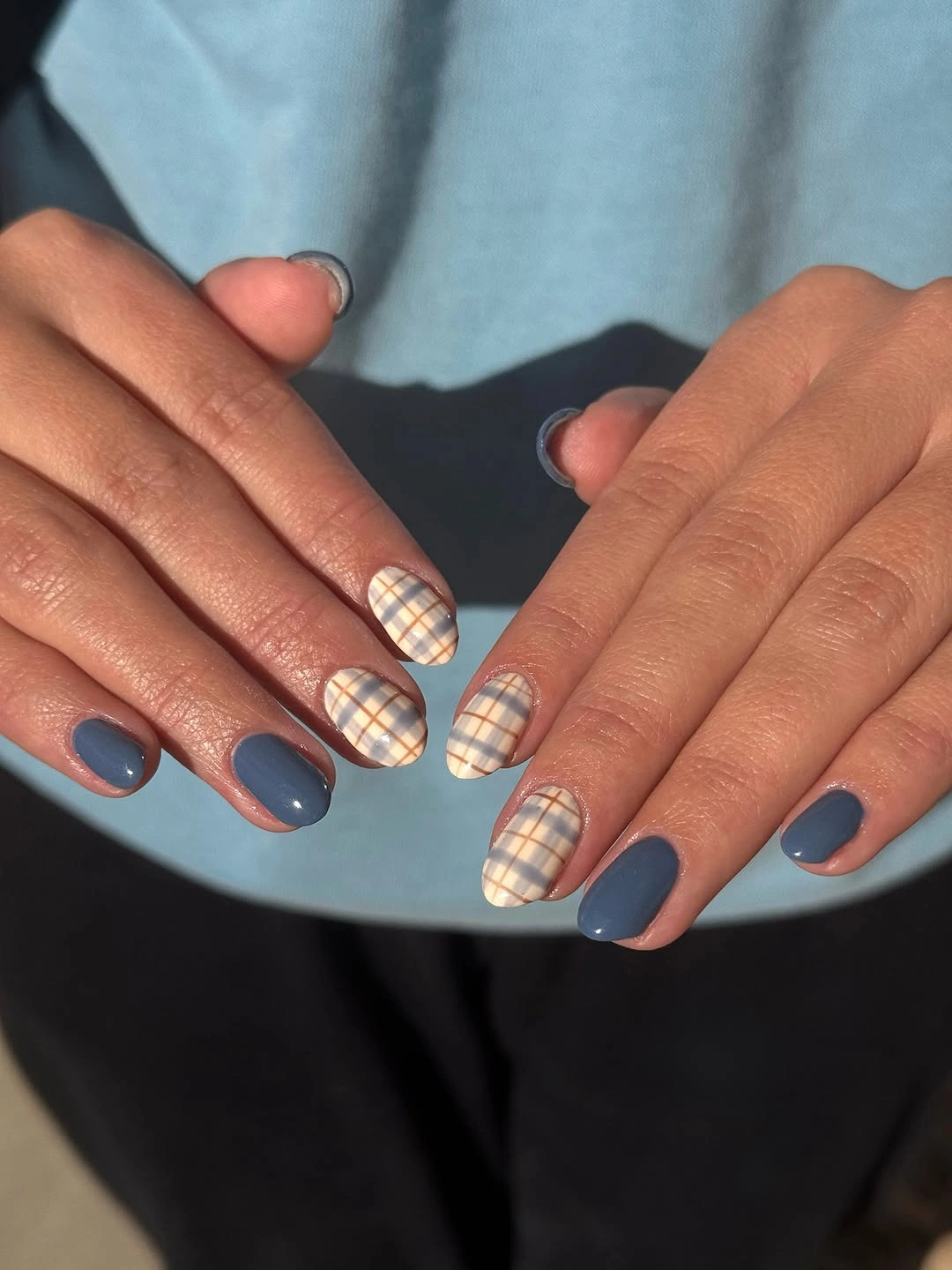 Short rounded-square blue nails with cream plaid accents