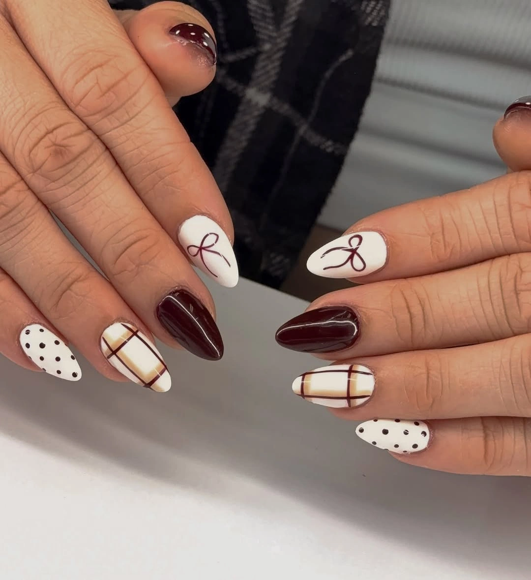 Burgundy almond nails with cream plaid dots and bow accents