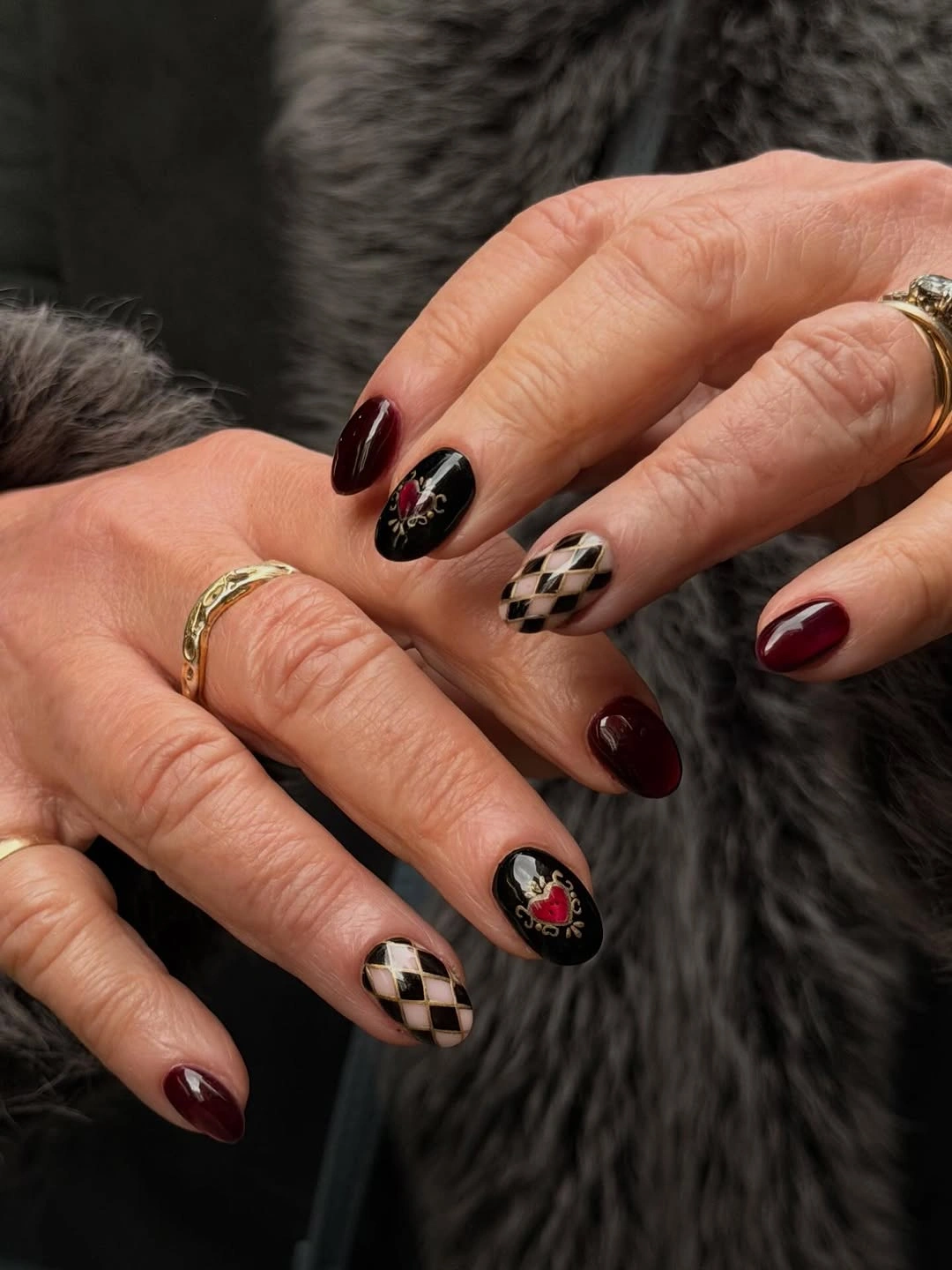 Oval nails with burgundy, checkerboard, and black illustrated accents