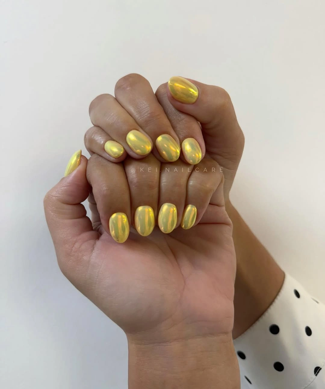 Short oval nails with bright reflective yellow-gold finish