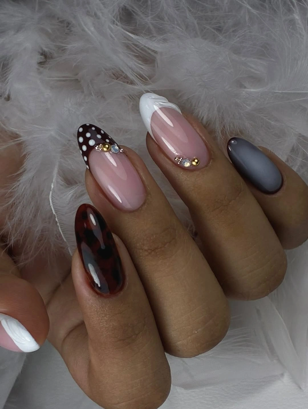 Almond nails mixing pink, dark marbling, white tips, and gray