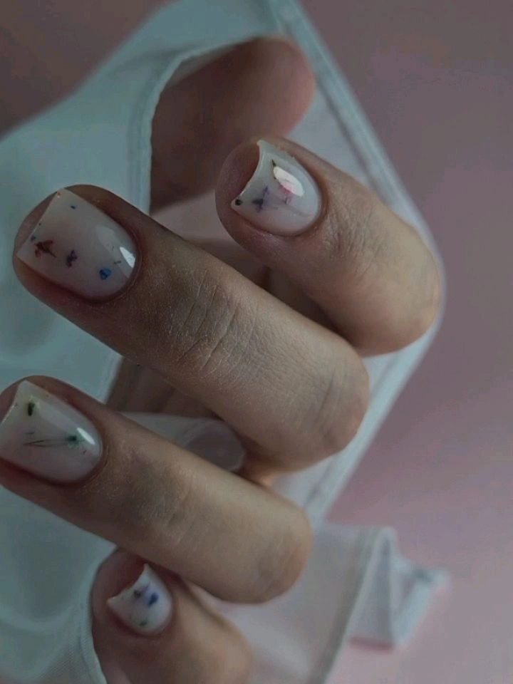 Very short milky nails with tiny multicolor marks and edge lines