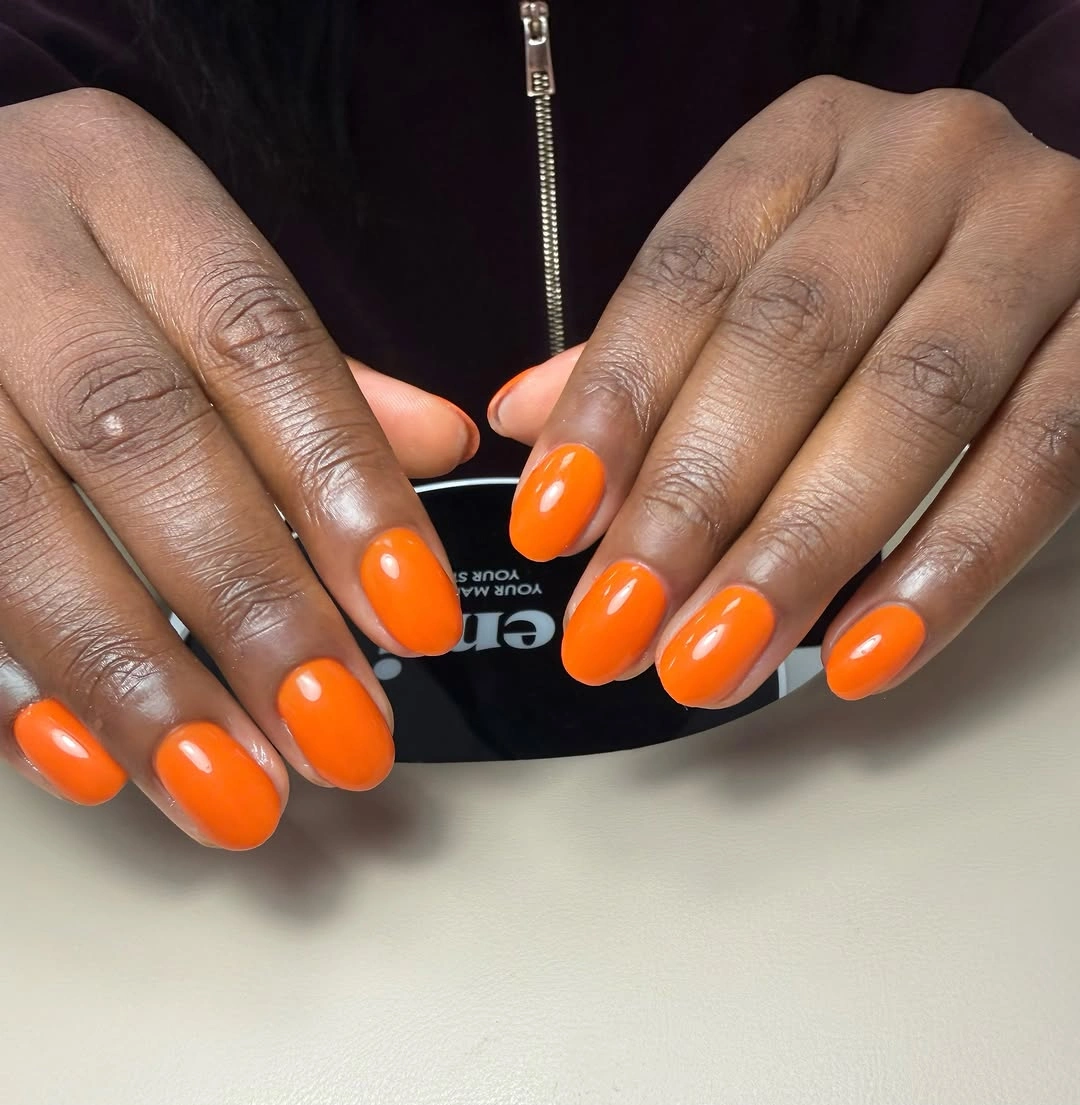 Short-to-medium oval nails in vivid glossy orange