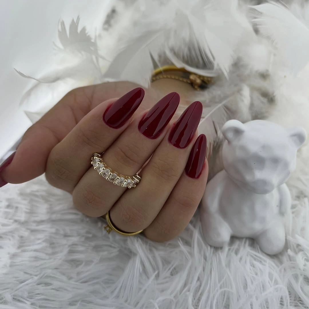 Long almond nails in glossy deep wine-burgundy
