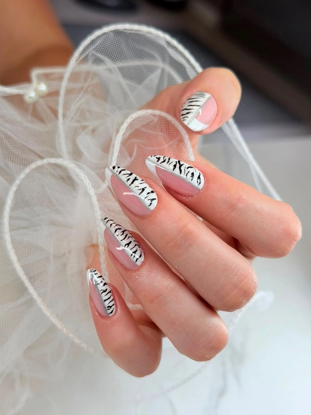 Almond nails with white angled tips and black branching linework